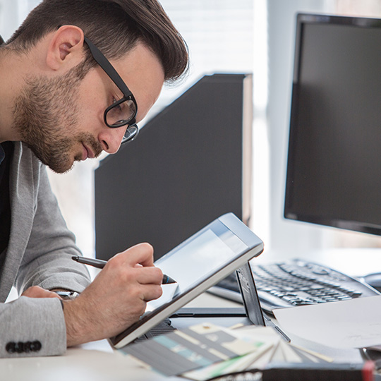 man working on a tablet with a stylus
