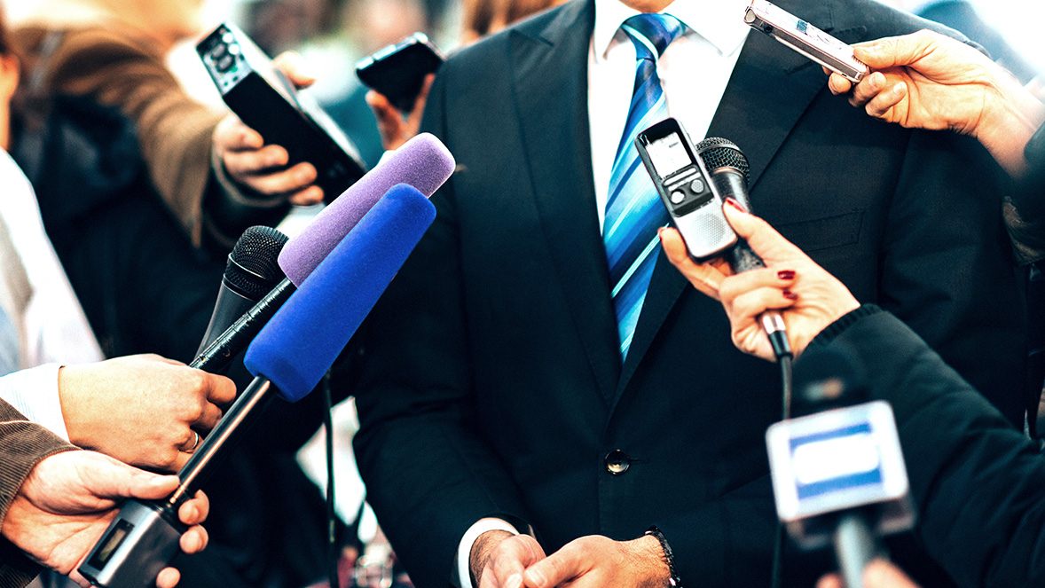 close up of businessman surrounded by microphones close up of businessman surrounded by microphones