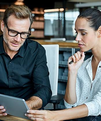 Nieuwe teamleden sneller wegwijs maken two colleagues looking at a tablet together
