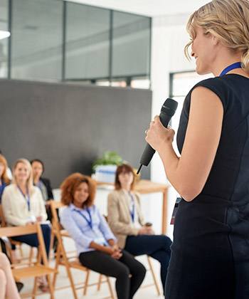 Leren en ontwikkelen woman presenting in front of a group